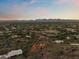 Sunset aerial view showcases the home in a community against a stunning mountain backdrop at 6349 E Hummingbird Ln, Paradise Valley, AZ 85253