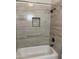 Bathroom showcasing tiled walls, a shower head and a built-in niche at 7052 E Kessler Ave, Mesa, AZ 85209
