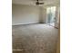 Spacious bedroom with neutral carpet, a ceiling fan, and sliding glass door to the outside at 7052 E Kessler Ave, Mesa, AZ 85209