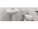 Bright bathroom features a pedestal sink, toilet, and tile flooring at 7413 S 32Nd Dr, Phoenix, AZ 85041