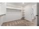 Walk-in closet featuring open shelving and carpeted floors at 7413 S 32Nd Dr, Phoenix, AZ 85041