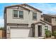 Charming two-story home featuring a two-car garage, desert landscaping, and a welcoming front entrance at 7413 S 32Nd Dr, Phoenix, AZ 85041
