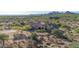 An aerial view of a desert home with decorative tile roof, desert landscaping, and mountain views at 8024 E Lone Mountain Rd, Scottsdale, AZ 85266