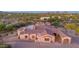 Aerial view showcases a luxury home with stone accents, a portico, and a lush desert landscape at 8024 E Lone Mountain Rd, Scottsdale, AZ 85266