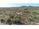 Custom home with a long driveway through the desert landscape with mountain views at 8024 E Lone Mountain Rd, Scottsdale, AZ 85266
