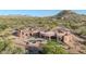 Custom home with a pool, patio, and a tile roof nestled in a lush desert landscape at 8024 E Lone Mountain Rd, Scottsdale, AZ 85266