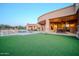 Spacious backyard featuring a pool, hot tub, covered patio and well-maintained artificial grass at 8024 E Lone Mountain Rd, Scottsdale, AZ 85266