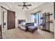 Bedroom with a wooden bed, dark wooden door, and open shelving with sports equipment at 8024 E Lone Mountain Rd, Scottsdale, AZ 85266