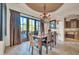 Elegant dining room with doors to the outdoor living space, wood table and tray ceilings at 8024 E Lone Mountain Rd, Scottsdale, AZ 85266