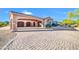 The decorative driveway leads to garages, a portico, and desert landscaping at 8024 E Lone Mountain Rd, Scottsdale, AZ 85266