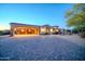 Large circular driveway featuring intricate paver design, leading to a grand home with porte-cochere at 8024 E Lone Mountain Rd, Scottsdale, AZ 85266