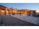 Stunning desert home with a pool, expansive patio, and elegant architectural details at twilight at 8024 E Lone Mountain Rd, Scottsdale, AZ 85266