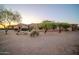 Single Gathering home with desert landscaping, a circular wall, and sunset sky at 8024 E Lone Mountain Rd, Scottsdale, AZ 85266