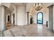 Grand foyer with ornate wrought iron door, chandelier, travertine floors and arched doorways at 8024 E Lone Mountain Rd, Scottsdale, AZ 85266