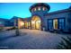 Elegant home with a stone turret entrance, decorative iron door, and paver driveway at 8024 E Lone Mountain Rd, Scottsdale, AZ 85266