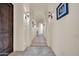 Elegant hallway featuring arched doorways, sconce lighting, and light tile flooring at 8024 E Lone Mountain Rd, Scottsdale, AZ 85266