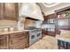 A chef's kitchen with stainless steel appliances, custom cabinetry, and a granite countertop at 8024 E Lone Mountain Rd, Scottsdale, AZ 85266