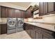 Laundry room featuring high-end washer, dryer, cabinets, and granite counter at 8024 E Lone Mountain Rd, Scottsdale, AZ 85266