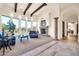 Open living room with stone fireplace, beamed ceilings, and a seamless flow to the outdoors at 8024 E Lone Mountain Rd, Scottsdale, AZ 85266