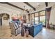 Comfortable living room with beamed ceilings, tile floors, stone fireplace and access to the wet bar at 8024 E Lone Mountain Rd, Scottsdale, AZ 85266