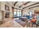Open living room seamlessly connects to the outdoor patio, kitchen and features a stone fireplace at 8024 E Lone Mountain Rd, Scottsdale, AZ 85266