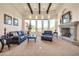 Inviting living room with a stone fireplace, beamed ceilings, and a wall of windows at 8024 E Lone Mountain Rd, Scottsdale, AZ 85266