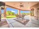A covered patio with dining table, ceiling fan, and views of the green lawn at 8024 E Lone Mountain Rd, Scottsdale, AZ 85266