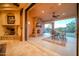 Covered patio featuring a stone fireplace and a dining area, seamlessly connected to the interior living space at 8024 E Lone Mountain Rd, Scottsdale, AZ 85266