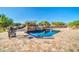 Backyard pool with stone deck, waterfall feature, iron chairs, and desert landscaping at 8024 E Lone Mountain Rd, Scottsdale, AZ 85266