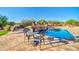 A backyard with travertine decking features a pool, spa, table, and BBQ at 8024 E Lone Mountain Rd, Scottsdale, AZ 85266