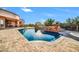 A beautiful backyard with a pool, spa, waterfall feature, and travertine decking at 8024 E Lone Mountain Rd, Scottsdale, AZ 85266