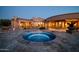 Tranquil backyard with a custom pool and spa, complemented by mature landscaping and desert views at 8024 E Lone Mountain Rd, Scottsdale, AZ 85266