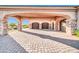 Arched portico of a desert home leading to garages and desert landscaping at 8024 E Lone Mountain Rd, Scottsdale, AZ 85266
