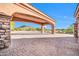 An arched portico with stone columns leads to a desert landscape under a clear blue sky at 8024 E Lone Mountain Rd, Scottsdale, AZ 85266
