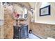 Stylish powder room featuring textured stone walls, a unique vessel sink, and decorative mirror at 8024 E Lone Mountain Rd, Scottsdale, AZ 85266