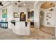 Open wet bar with granite countertop, custom cabinetry, wine fridge, and decorative wrought iron doorway at 8024 E Lone Mountain Rd, Scottsdale, AZ 85266