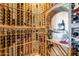 Custom wine cellar with wooden racks and arched alcove for displaying bottles and accessories at 8024 E Lone Mountain Rd, Scottsdale, AZ 85266