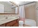 Cozy bathroom with floral wallpaper, wood framed mirror, and shower with bathtub at 9797 N 100Th Pl, Scottsdale, AZ 85258