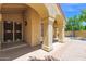 Charming stucco facade with arched entryway, offering a glimpse of the tile flooring of the front porch at 9797 N 100Th Pl, Scottsdale, AZ 85258