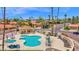 Aerial view of a large, uniquely shaped pool with tables, chairs, lounge seating, and multiple palm trees at 9797 N 100Th Pl, Scottsdale, AZ 85258