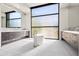 Bright bathroom with a freestanding tub, dual vanities, and large windows offering an abundance of natural light at 10641 E Blue Sky Dr, Scottsdale, AZ 85262