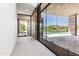 Bright hallway with floor-to-ceiling windows overlooking the patio, pool, and desert landscaping at 10641 E Blue Sky Dr, Scottsdale, AZ 85262