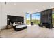Bright main bedroom featuring a large window with scenic views, accent fireplace, and modern decor at 10641 E Blue Sky Dr, Scottsdale, AZ 85262