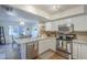 Bright kitchen showcasing stainless steel appliances, white cabinets, and a view into the dining area at 11416 N Century Ln, Scottsdale, AZ 85254