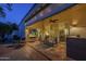Inviting covered patio features comfortable seating, seamless access to the interior through sliding glass doors, and evening lighting at 11416 N Century Ln, Scottsdale, AZ 85254