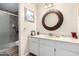 Bathroom featuring a modern shower, vanity with sink, and a decorative mirror at 13889 N 108Th Dr, Sun City, AZ 85351