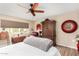 Relaxing bedroom featuring a cozy bed, window with a view, and rustic decor at 13889 N 108Th Dr, Sun City, AZ 85351