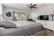 Relaxing bedroom with gray bedding, a ceiling fan, and sliding glass door to the patio at 13889 N 108Th Dr, Sun City, AZ 85351