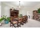 Bright dining room boasts a large wooden table and chairs, with elegant display cabinet at 13889 N 108Th Dr, Sun City, AZ 85351