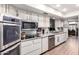 Well-lit kitchen with stainless steel appliances, white cabinets, and a functional layout at 13889 N 108Th Dr, Sun City, AZ 85351